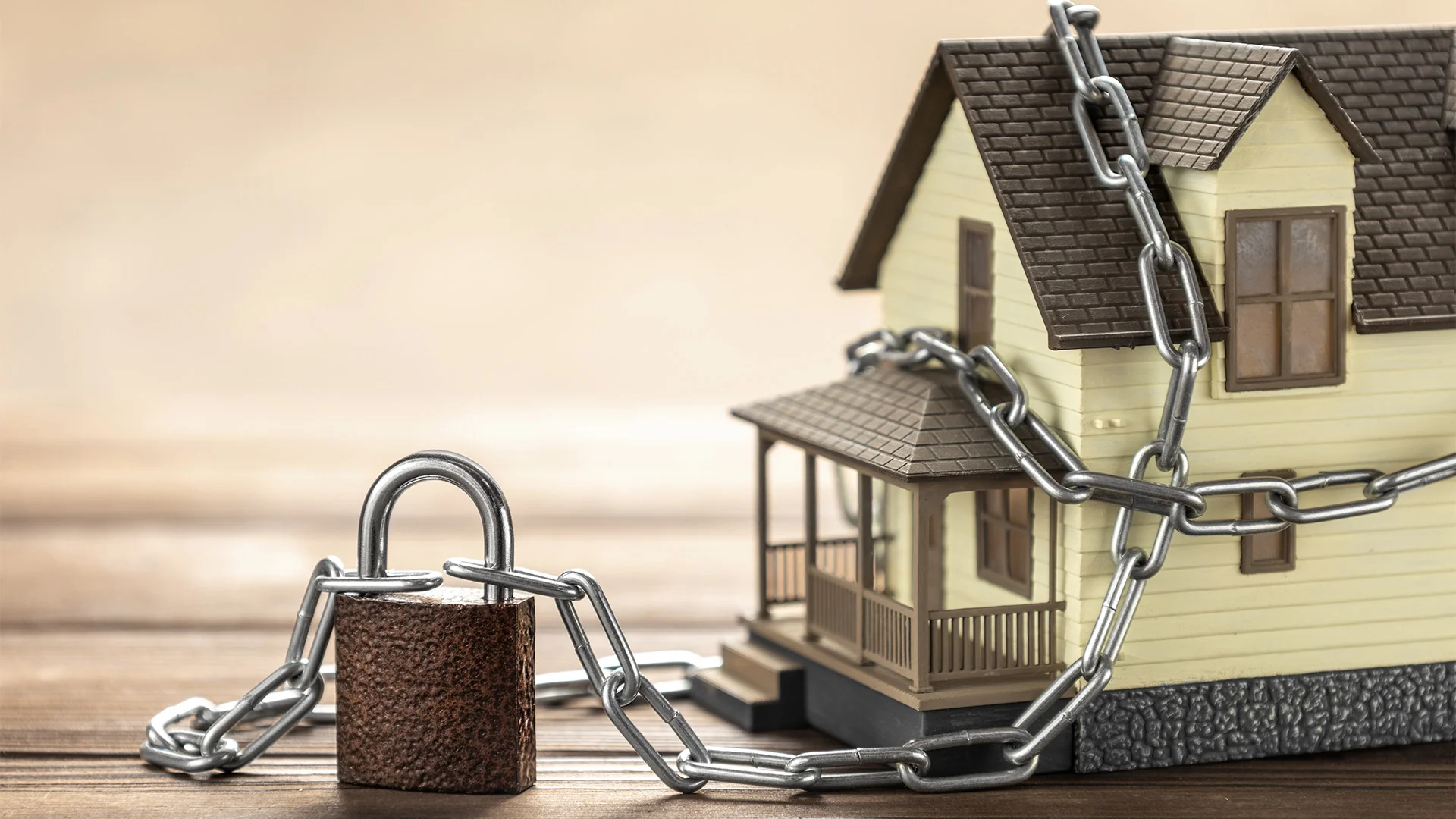 Захист житла від продажу: модель будинку в ланцюгах із замком