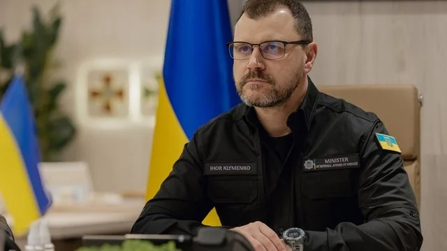 Ігор Клименко у формі міністра внутрішніх справ на тлі прапорів України