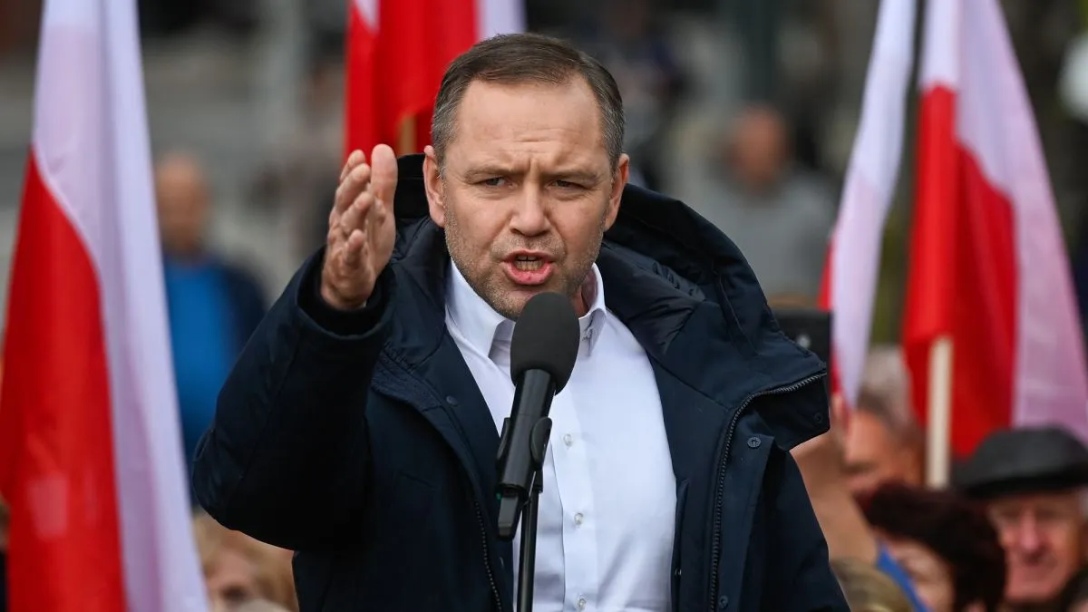 Кароль Навроцький виступає на мітингу з польськими прапорами на фоні