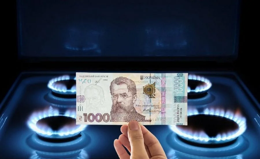 Рука тримає 1000 гривень над газовою плитою з полумям