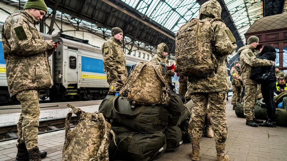 Українські військові зі спорядженням на вокзалі під час мобілізації