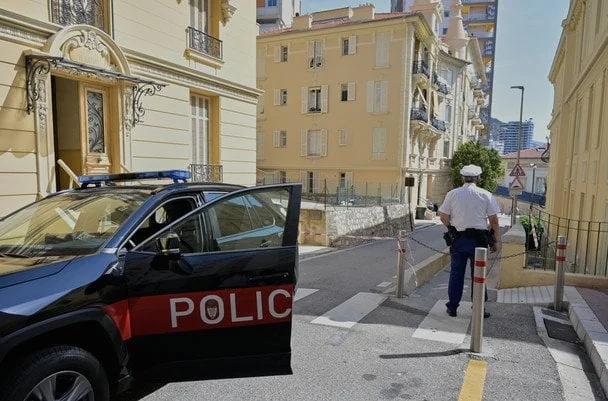 Поліцейський автомобіль з відкритими дверима та офіцер на вулиці Монако