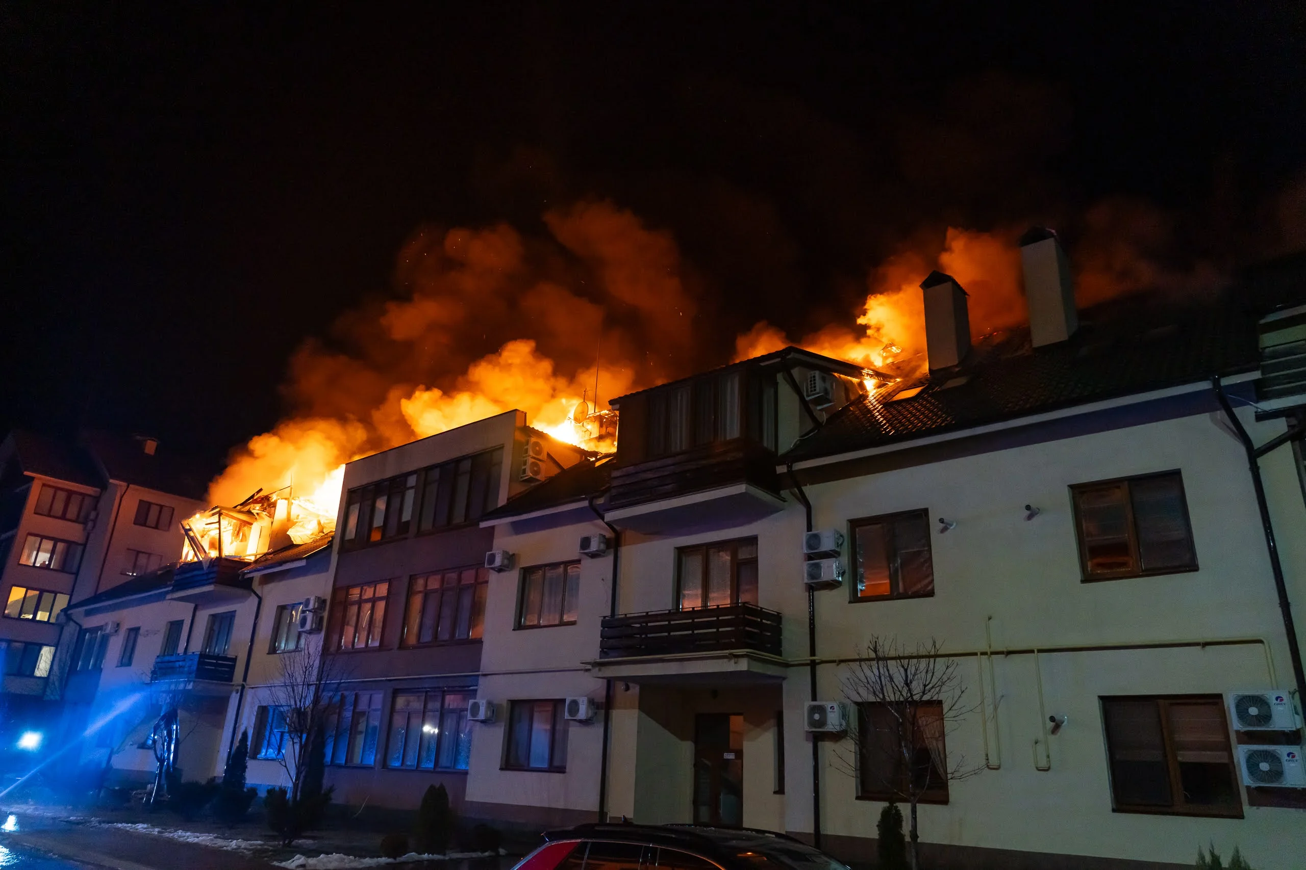 Нічна пожежа на даху житлових будинків із яскравим полумям і димом